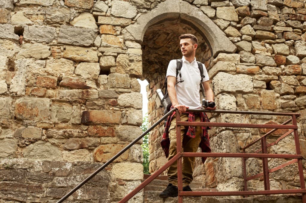 Un viaggiatore esplora un arco in pietra.